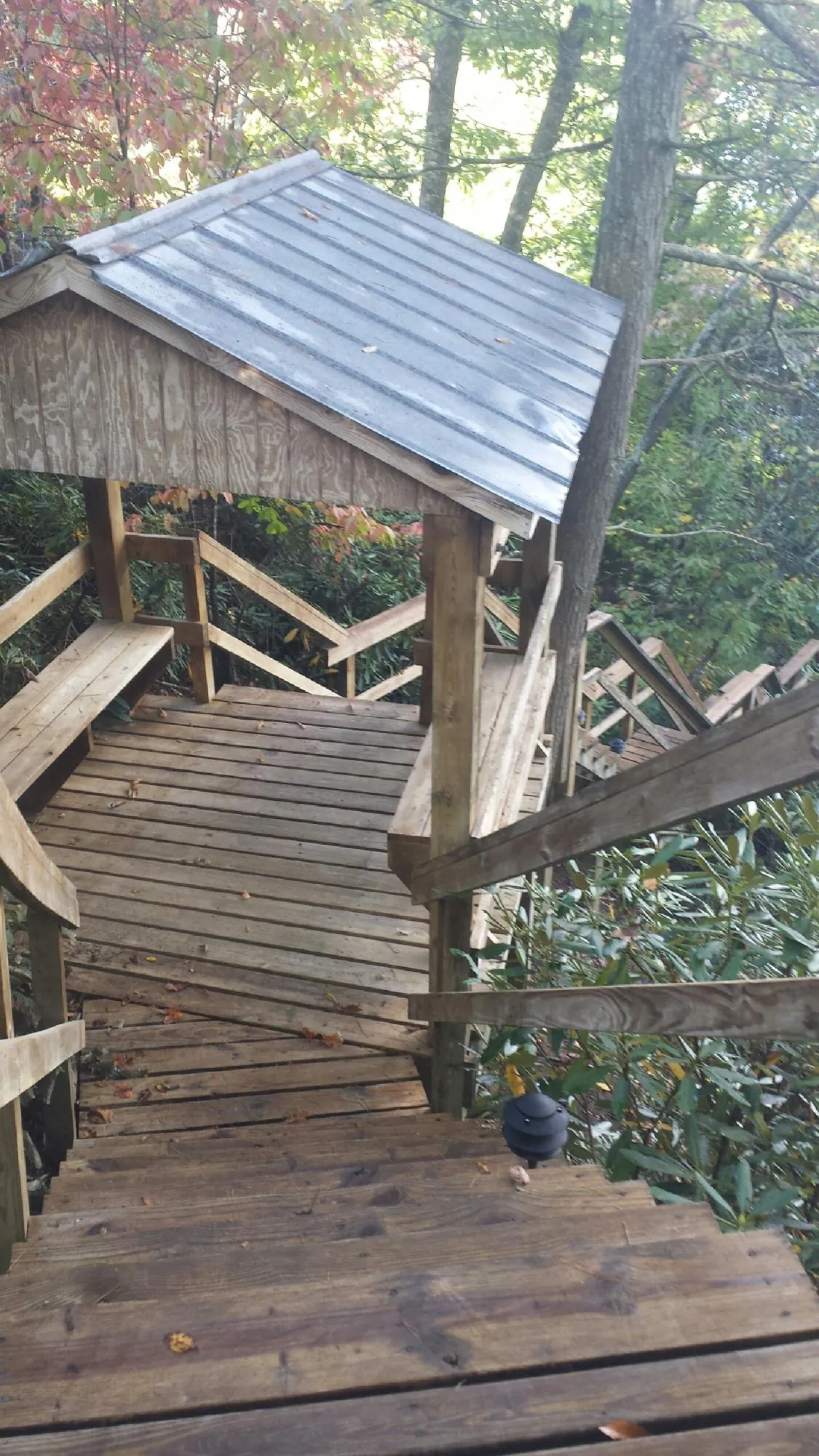 Metal roofed shelter over wooden steps on a wooded walkway — Skylight Repair & Installation work by our crew in Yorktown